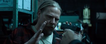 Movie still from “Death Wish” (2018), directed by Eli Roth – A man with long hair and a goatee is looking at a cell phone; Close Up shot, Over the shoulder angle