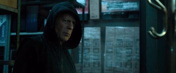 Movie still from “Death Wish” (2018), directed by Eli Roth – A man wearing a black hooded jacket in front of a wall; Close Up shot, Low angle