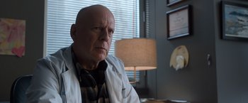Movie still from “Death Wish” (2018), directed by Eli Roth – An older man sitting in front of a lamp; Close Up shot, Low angle