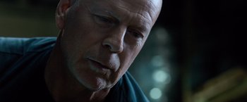 Movie still from “Death Wish” (2018), directed by Eli Roth – An older bald man with a goatee looking to his left; Close Up shot, Low angle