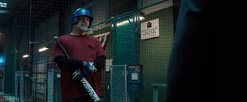Movie still from “Death Wish” (2018), directed by Eli Roth – A man holding a baseball bat while standing next to a cage; Medium shot, Over the shoulder angle