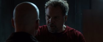 Movie still from “Death Wish” (2018), directed by Eli Roth – A man in a red t - shirt talking to another man in a red t - shirt; Close Up shot, Over the shoulder angle