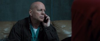 Movie still from “Death Wish” (2018), directed by Eli Roth – A bald man is talking on a cell phone; Close Up shot, Low angle