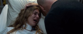Movie still from “Death Wish” (2018), directed by Eli Roth – A woman in a hospital bed crying with a man touching her head; Close Up shot, Over the shoulder angle