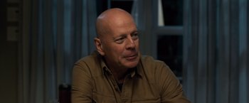 Movie still from “Death Wish” (2018), directed by Eli Roth – A bald man in a brown shirt is looking at the camera; Close Up shot, Over the shoulder angle
