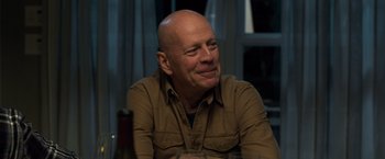Movie still from “Death Wish” (2018), directed by Eli Roth – A man with a bald head sitting at a table; Close Up shot, Over the shoulder angle