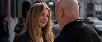 Movie still from “Death Wish” (2018), directed by Eli Roth – A beautiful young woman smiling at a bald headed man; Close Up shot, Over the shoulder angle