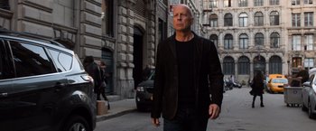 Movie still from “Death Wish” (2018), directed by Eli Roth – A man in a black jacket walking down the street; Medium shot, Low angle