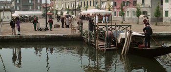 Movie still from “Death in Venice” (1971), directed by Luchino Visconti – A group of people standing on a pier near a body of water; Extreme Wide shot, High angle
