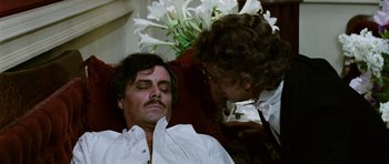 Movie still from “Death in Venice” (1971), directed by Luchino Visconti – An older man with a mustache is laying in a chair; Close Up shot, Over the shoulder angle