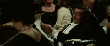 Movie still from “Death in Venice” (1971), directed by Luchino Visconti – A man sitting in a chair looking at papers; Medium shot, Over the shoulder angle