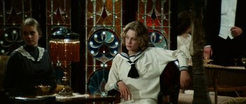 Movie still from “Death in Venice” (1971), directed by Luchino Visconti – A woman sitting in a chair in front of a stained glass window; Medium shot, Over the shoulder angle