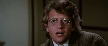 Movie still from “Death in Venice” (1971), directed by Luchino Visconti – A person wearing glasses and a suit; Close Up shot, Over the shoulder angle