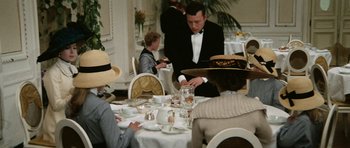 Movie still from “Death in Venice” (1971), directed by Luchino Visconti – A group of people sitting at a table with plates of food; Medium shot, High angle
