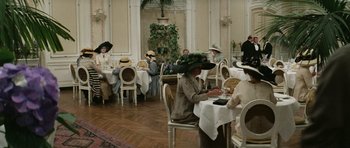 Movie still from “Death in Venice” (1971), directed by Luchino Visconti – A group of people sitting at tables in a room; Wide shot, High angle
