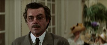 Movie still from “Death in Venice” (1971), directed by Luchino Visconti – A person wearing a suit and glasses; Close Up shot, Over the shoulder angle