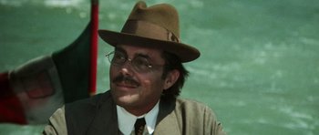 Movie still from “Death in Venice” (1971), directed by Luchino Visconti – A man in a hat and glasses sitting in a boat; Close Up shot, Over the shoulder angle