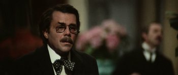 Movie still from “Death in Venice” (1971), directed by Luchino Visconti – A person wearing a suit and a bow tie; Close Up shot, Over the shoulder angle