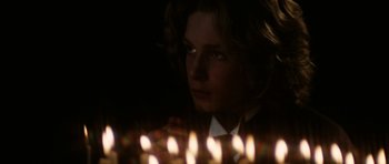 Movie still from “Death in Venice” (1971), directed by Luchino Visconti – A young man is looking at the camera with candles in the background; Close Up shot, Over the shoulder angle
