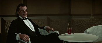 Movie still from “Death in Venice” (1971), directed by Luchino Visconti – A man sitting at a table with a cigarette in his hand; Medium shot, Over the shoulder angle