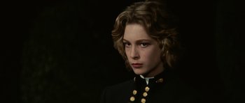 Movie still from “Death in Venice” (1971), directed by Luchino Visconti – A woman in a military uniform is looking at the camera; Close Up shot, Over the shoulder angle