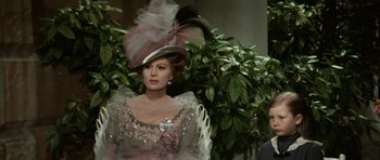 Movie still from “Death in Venice” (1971), directed by Luchino Visconti – A woman wearing a hat and a dress with feathers; Medium shot, Over the shoulder angle