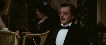 Movie still from “Death in Venice” (1971), directed by Luchino Visconti – A man in a tuxedo sitting next to a woman in a black dress; Close Up shot, Over the shoulder angle