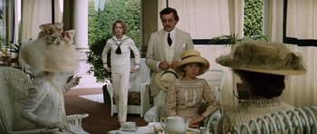 Movie still from “Death in Venice” (1971), directed by Luchino Visconti – A group of people sitting at a table with tea cups; Medium shot, Over the shoulder angle