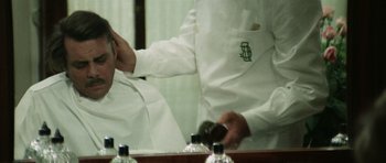 Movie still from “Death in Venice” (1971), directed by Luchino Visconti – A man in a white shirt is combing his hair; Close Up shot, Over the shoulder angle