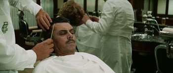 Movie still from “Death in Venice” (1971), directed by Luchino Visconti – A man getting his hair cut at a barber shop; Close Up shot, Over the shoulder angle