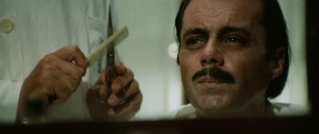 Movie still from “Death in Venice” (1971), directed by Luchino Visconti – A person holding a comb in his hand; Close Up shot, Low angle
