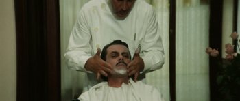 Movie still from “Death in Venice” (1971), directed by Luchino Visconti – A man getting his face shaven by a barber; Close Up shot, Over the shoulder angle