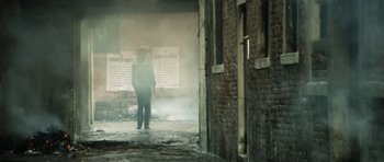 Movie still from “Death in Venice” (1971), directed by Luchino Visconti – A man standing in front of an old brick building; Wide shot, Low angle