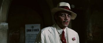 Movie still from “Death in Venice” (1971), directed by Luchino Visconti – A man in a white suit and a red hat; Close Up shot, Low angle