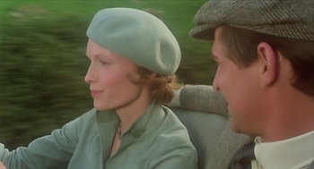 Movie still from “Death on the Nile” (1978), directed by John Guillermin – A woman sitting next to a man in a car; Close Up shot, Over the shoulder angle
