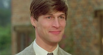 Movie still from “Death on the Nile” (1978), directed by John Guillermin – A person wearing a suit and tie; Close Up shot, Over the shoulder angle