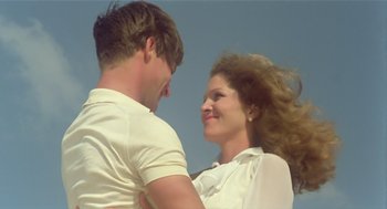 Movie still from “Death on the Nile” (1978), directed by John Guillermin – A man and a woman are smiling for the camera; Medium shot, Low angle