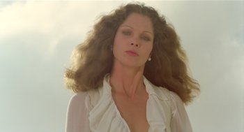 Movie still from “Death on the Nile” (1978), directed by John Guillermin – A beautiful woman with long brown curly hair wearing a white shirt; Close Up shot, Low angle