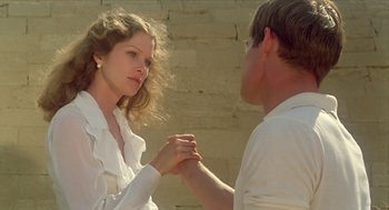 Movie still from “Death on the Nile” (1978), directed by John Guillermin – A man and a woman holding hands in front of a brick wall; Close Up shot, Low angle