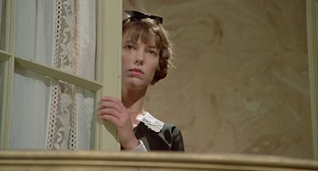 Movie still from “Death on the Nile” (1978), directed by John Guillermin – A woman in a black dress leaning against a window sill; Close Up shot, Low angle