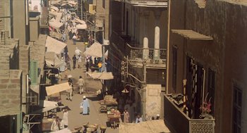 Movie still from “Death on the Nile” (1978), directed by John Guillermin – An aerial view of an open air market in a city; Extreme Wide shot, High angle