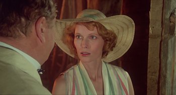 Movie still from “Death on the Nile” (1978), directed by John Guillermin – A person wearing a hat; Close Up shot, Over the shoulder angle