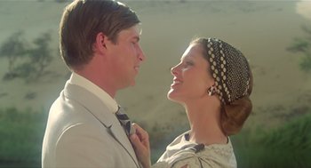 Movie still from “Death on the Nile” (1978), directed by John Guillermin – A man and a woman standing next to each other; Close Up shot, Low angle