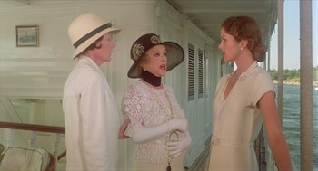 Movie still from “Death on the Nile” (1978), directed by John Guillermin – A group of women standing next to each other in a room; Medium shot, Over the shoulder angle