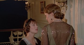 Movie still from “Death on the Nile” (1978), directed by John Guillermin – Two women are standing next to each other in a room; Medium shot, Over the shoulder angle