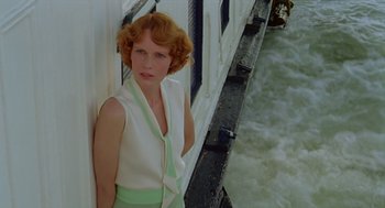 Movie still from “Death on the Nile” (1978), directed by John Guillermin – A woman standing next to a wall on a boat; Medium shot, Low angle