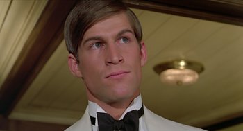Movie still from “Death on the Nile” (1978), directed by John Guillermin – A person wearing a suit and bow tie; Close Up shot, Low angle
