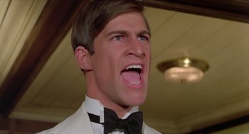 Movie still from “Death on the Nile” (1978), directed by John Guillermin – A person wearing a suit and tie; Close Up shot, Low angle