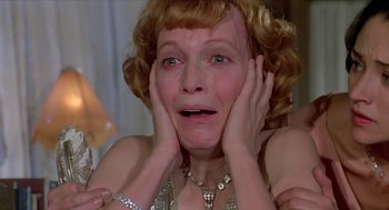 Movie still from “Death on the Nile” (1978), directed by John Guillermin – An older woman is holding her hands to her face; Close Up shot, Low angle