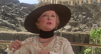 Movie still from “Death on the Nile” (1978), directed by John Guillermin – An older woman wearing a hat and holding a fan; Close Up shot, Low angle